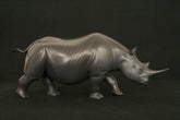 bronze sculpture of black rhino walking with dark grey patination