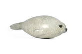 Bronze sculpture of seal pup laying on a white background