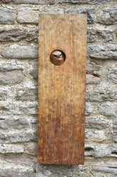 Bronze plaque with a circular cutout featuring an owl design, attached to a stone wall.