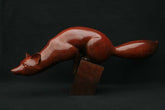 Bronze sculpture of red fox balancing on a small block base.