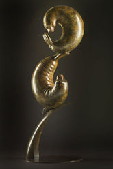 Bronze sculpture of two seals interacting on a dark background