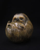 Bronze sculpture of a sloth curled up in a ball