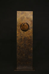 Bronze sculpture of bird in a sculptural form plaque on a black background.