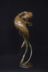 Bronze sculpture of a figure with flowing hair on a black background