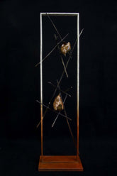 Bronze sculpture of two wren birds in a large frame surrounded by small branches on a black background.