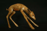 Bronze sculpture of a deer on a black background
