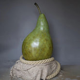 Green pear on a textured surface with a gray background
