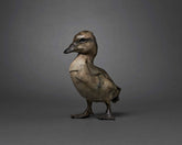 Bronze duck sculpture on a gray background