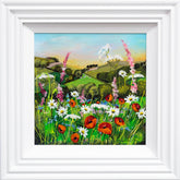 Framed artwork of a colorful landscape with flowers and rolling hills.