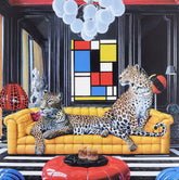 Two leopards on a yellow couch in a stylish room with colorful decor