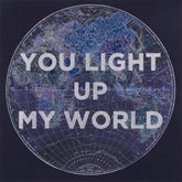 World map with 'You light up my world' text overlay on a dark background