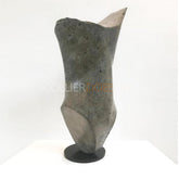 A modern abstract bronze sculpture with a twisted, organic body shape