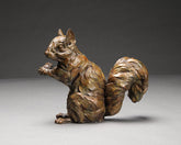 Bronze sculpture of a squirrel on a gray background