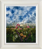 Framed artwork of a field of flowers with a blue sky.