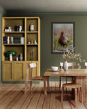 framed bird artwork on green kitchen wall next to yellow cabinet.