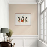 Framed artwork of three roosters on a beige wall above a white cabinet.