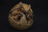 Bronze sculpture of an armadillo on a black background