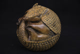 Bronze sculpture of an armadillo on a black background