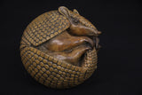 Bronze sculpture of an armadillo on a black background