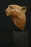 Bronze sculpture of a cheetah head on a  black base on black background