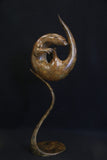 Bronze otter curled up and fixed to a matching curved stand