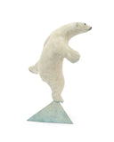 white polar bear balancing on one foot on a triangle base.