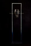 Bronze sculpture of two birds perched on a metal stand against a black background