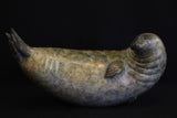Bronze sculpture of a seal on a black background