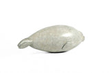 Bronze sculpture of seal pup laying on a white background