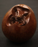 Small bronze hedgehog curled up in a ball
