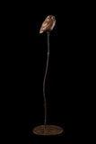 Bronze sculpture of an owl perched on a branch against a black background