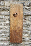 Bronze plaque with a circular cutout featuring an owl design, attached to a stone wall.