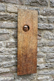 Bronze plaque with a circular cutout featuring an owl design, attached to a stone wall.