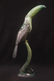 Bronze sculpture of muted green toucan bird on a stand