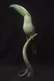 Bronze sculpture of muted green toucan bird on a stand
