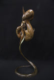 Bronze sculpture of two otters intertwined on a black background