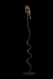 Bronze sculpture of bird perched on a long, thin branch against a black background
