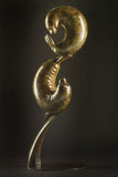 Bronze sculpture of two seals interacting on a dark background
