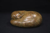 Brown stone sculpture of a cat on a black background
