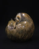 Bronze sculpture of a sloth curled up in a ball