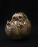 Bronze sculpture of a sloth curled up in a ball
