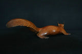 Bronze sculpture of a red squirrel on a black background