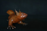 Bronze sculpture of a red squirrel on a black background