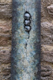 Decorative bronze panel with three birds on a stone wall close up