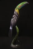 Bronze sculpture of vibrant toucan bird on a stand