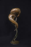 Bronze sculpture of two animals intertwined on a black background