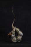 Bronze sculpture of wren perched inside a seed pod