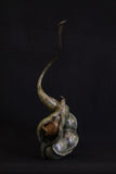 Bronze sculpture of wren perched inside a seed pod
