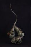 Bronze sculpture of wren perched inside a seed pod