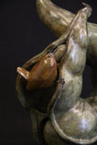 Bronze sculpture of wren perched inside a seed pod